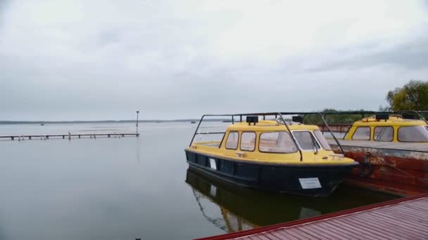 Желтая яхта пришвартована к пирсу на стоянке . — стоковое видео