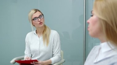 Psikolog, terapide sorunları hakkında konuşan müşteri kadını dikkatle dinliyor..