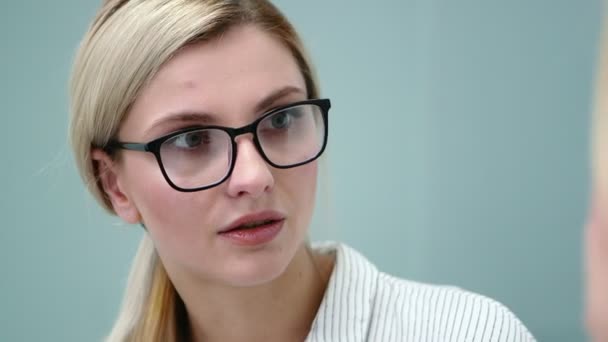 Junge Psychologin mit Brille spricht emotional mit ihrem Klienten. — Stockvideo