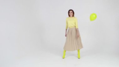 Young woman is dancing swish swish dance at light background.