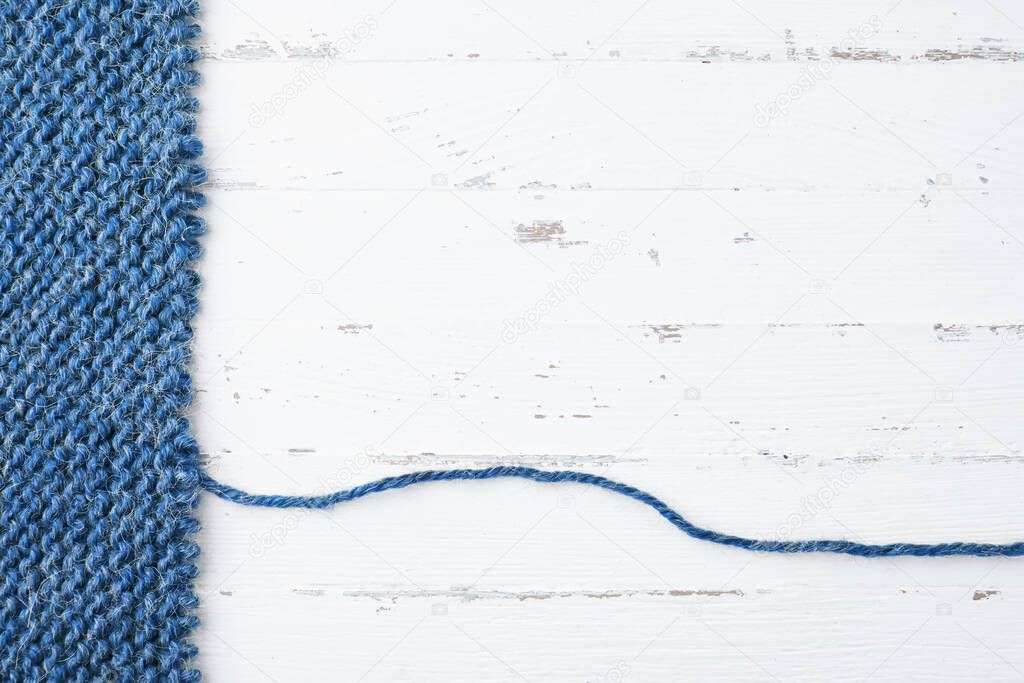 Unravelling knitted fabric on white background