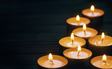 Koyu arkaplanda yanan sekiz mum
