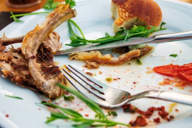 Sofrada yemek artıkları ve çatal bıçak takımı var.