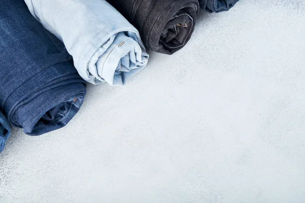 Row of rolled jeans on white background