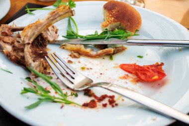 Sofrada yemek artıkları ve çatal bıçak takımı var.