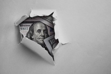 Kağıdın altında 100 dolarlık banknot.