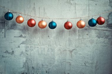Beton duvarda asılı renkli Noel topları