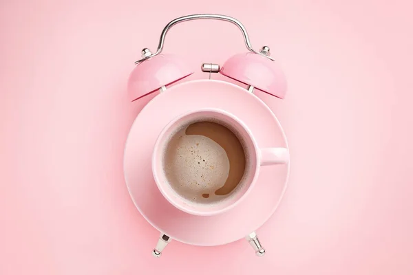 粉色背景的粉色闹钟和咖啡杯 早餐时间的概念 简约风格 — 图库照片