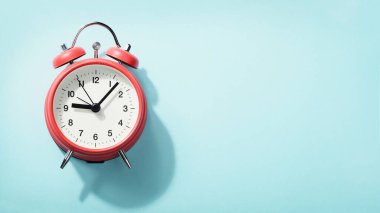 Mavi arka planda duran kırmızı alarmlı saat. Yukarıdan görüntüle.