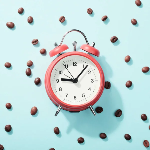 Red Alarm Clock Roasted Coffee Beans Blue Background Shadow Concept — Stock Photo, Image
