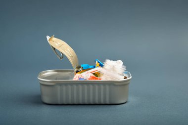 Teneke kutuyu aç. İçinde balık yerine plastik atık var. Okyanus plastik kirliliği kavramı
