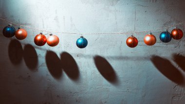 Beton duvarda asılı renkli Noel topları