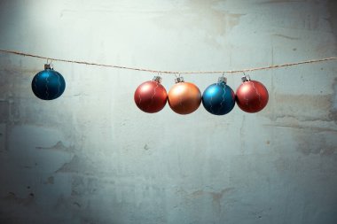Beton duvarda asılı renkli Noel topları