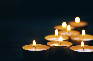 Koyu arkaplanda yanan sekiz mum. Seçici odak