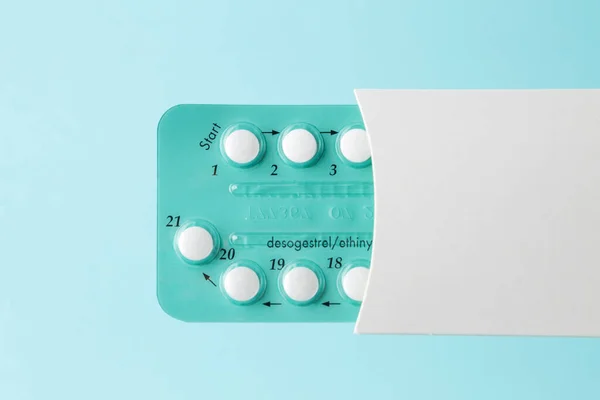 Pack of oral contraceptive pills with instructions. Blister in white case on blue background