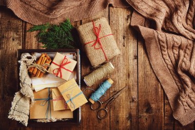 Noel, yeni yıl kompozisyonu hediye kutuları ve ahşap masaya örülmüş battaniye. Kış tatiline hazırlanıyorum.