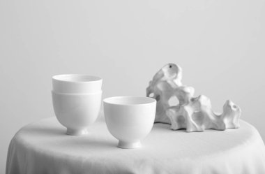 Beyaz çay bardak beyaz duvar arka plan üzerinde beyaz masa