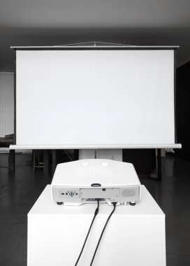 Ekran beyaz duvara yakın yerleştirilen projektör