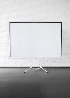 Ekran beyaz duvara yakın yerleştirilen projektör