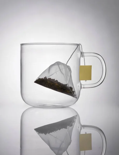 Close Van Glas Tea Cup Met Thee Packet Grijze Achtergrond — Stockfoto