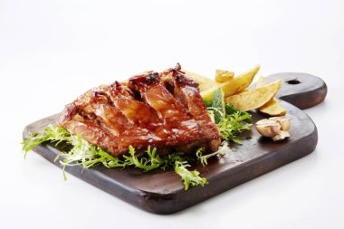 Kızarmış et, Fransız yangınlar ve üzerinde beyaz izole yeşillik ile ahşap kesme tahtası