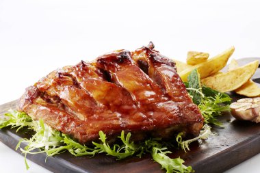 Kızarmış et, Fransız yangınlar ve üzerinde beyaz izole yeşillik ile ahşap kesme tahtası