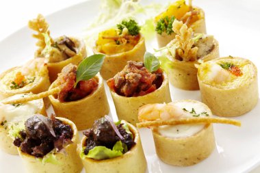 Beyaz arka planda lezzetli Batı yemekleri. Tabakta çeşitli tuzlu tatil atıştırmalıkları