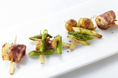 Küçük ahşap şişleri kızarmış et ve sebze snacks ile beyaz plaka closeup