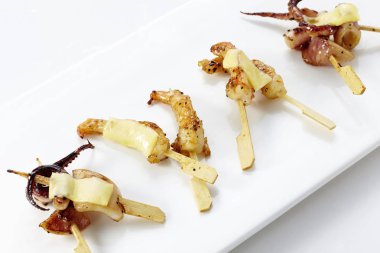 Küçük ahşap şişleri kızarmış et ve sebze snacks ile beyaz plaka closeup