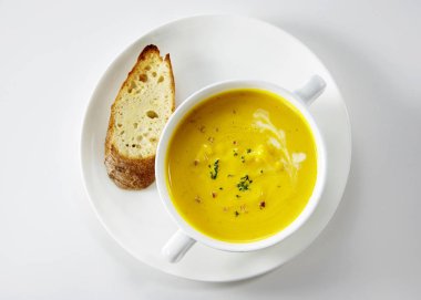 Çorba ve ekmek beyaz arka plan üzerinde hizmet plakalı closeup