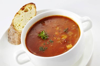 Çorba ve ekmek beyaz arka plan üzerinde hizmet plakalı closeup