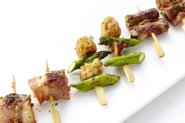 Küçük ahşap şişleri kızarmış et ve sebze snacks ile beyaz plaka closeup
