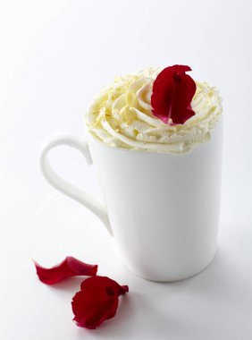 Krem ve kırmızı gül yaprakları üzerinde beyaz izole beyaz kahve fincanı closeup süslenmiş