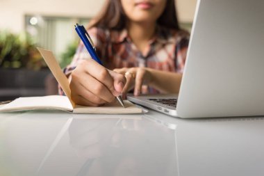 Not defteri tutan ve yazan kadının fotoğrafını kapat.