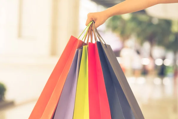 Фокус зображення жінки рука тримає барвисті сумки для покупок — стокове фото