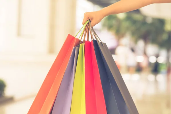 Fokus bild av kvinna hand hålla färgglada shoppingväskor — Stockfoto