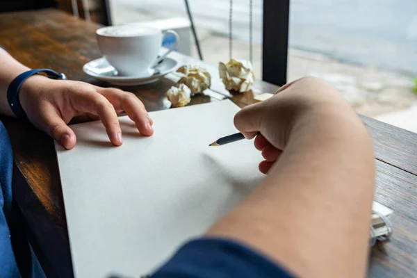 Людська рука малює на ескізі олівцем на кавовому — стокове фото