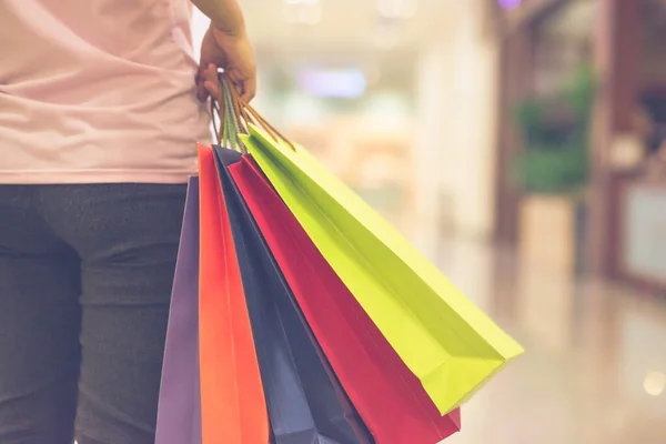 Feche a foto da mão da mulher segurando sacos de compras coloridos — Fotografia de Stock
