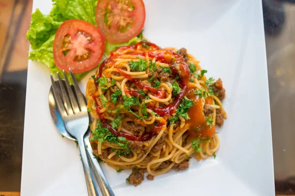 Вкусное блюдо из спагетти с фрикадельками и овощами с кетчупом — стоковое фото