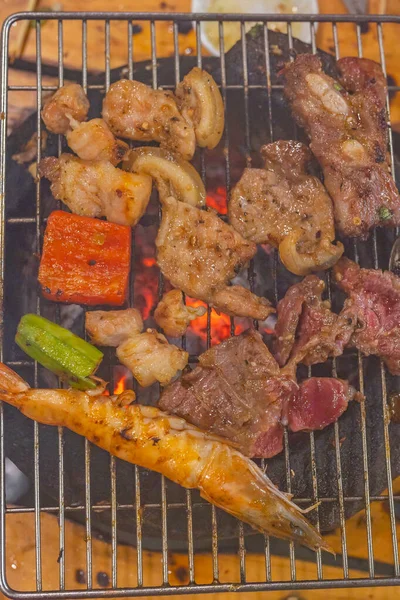 Foto vertical de carnes e camarão no fogão de grelhar carvão — Fotografia de Stock