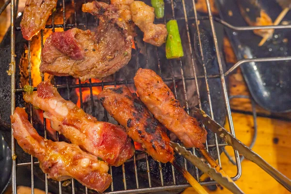 Foto de close-up de grelhar carne de churrasco no fogão a carvão em chamas — Fotografia de Stock