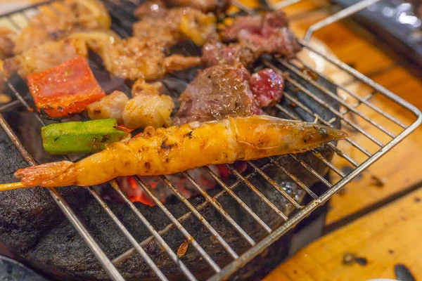 Camarão e sortimento de carne grelhando no fogão a carvão em chamas — Fotografia de Stock