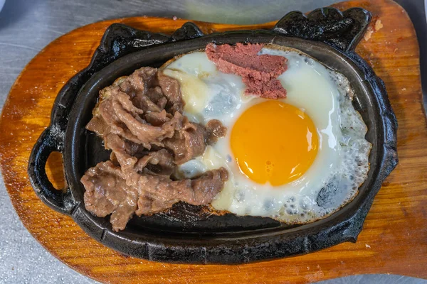 Lahodný hovězí steak a jedno vejce na syčícím talíři — Stock fotografie