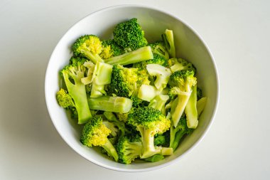 Beyaz arka planda izole edilmiş bir kase pişmiş brokoli.