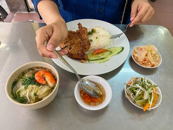 Woman eating Vietnamese pork chop rice with fish sauce — ストック写真