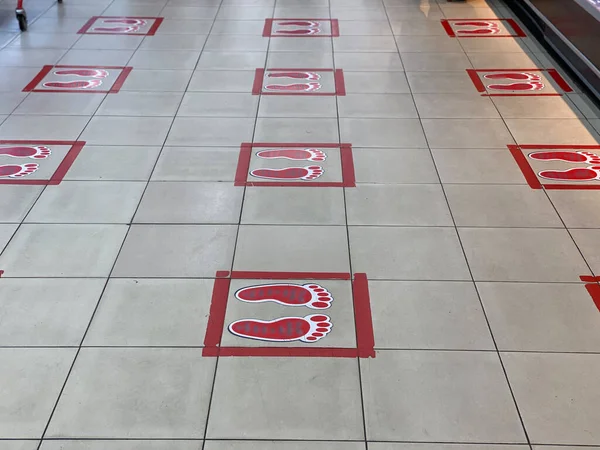 Footprint symbols on the floor at supermarket during COVID-19 — Stok fotoğraf