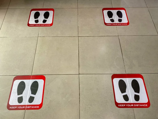 COVID-19期间，地板上用于社交距离的脚印符号 — 图库照片