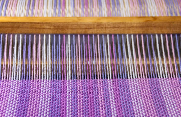 Kumaşın ultraviyole ve leylak renkleriyle dokuma tezgahındaki ayrıntıları