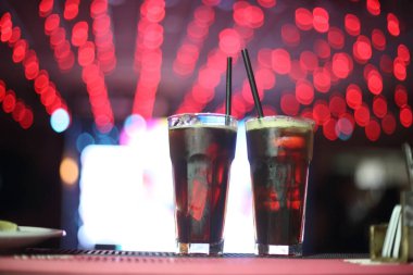 Barda arka ışıkları olan portakallı limonlu çeşitli içecekler.