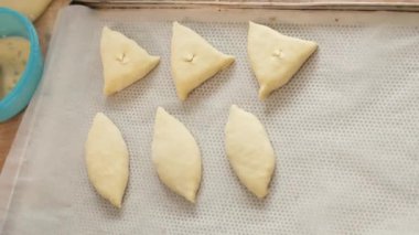 Baker el makas ile keser ve yumurta karışımı fırçayla köftesi üzerinde uğratan